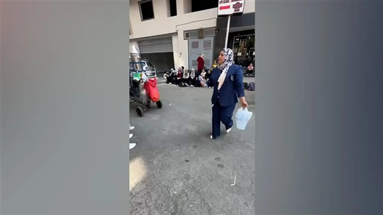 سيدة توزع زجاجات مياه على أولياء أمور طلاب الثانوية في الدقي لمواجهة حرارة الصيف (فيديو)